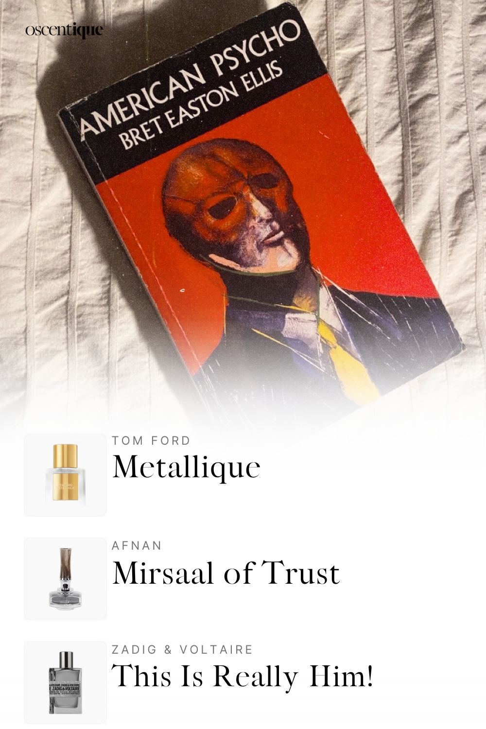 Paperback copy of American Psycho with mask-like face on cover, lying on pale rumpled sheets in soft light.